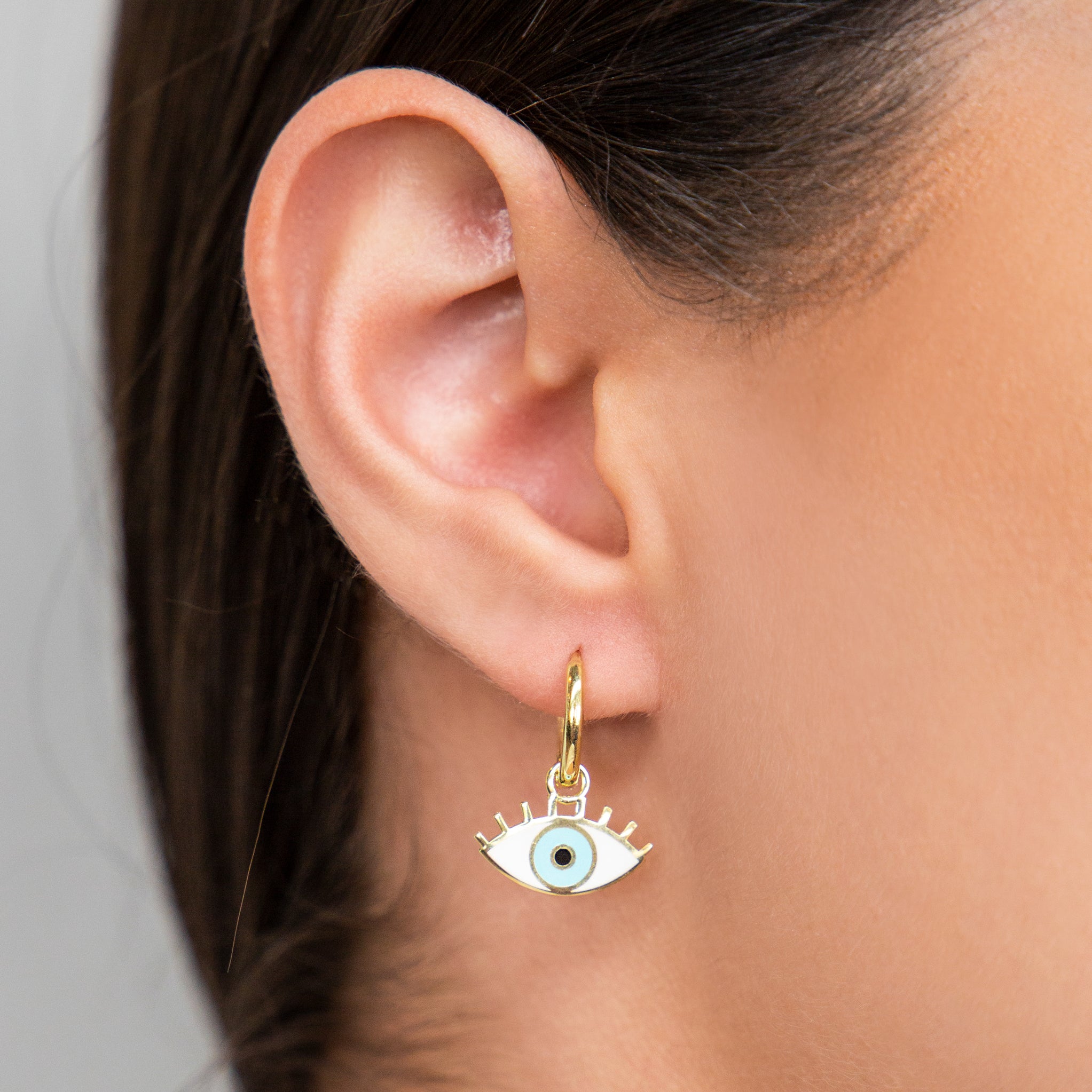 HUGGIES CON OJO TURCO CON ESMALTE BLANCO Y CELESTE EN PLATA 925 CON BAÑO DE ORO AMARILLO - C'SANTOS