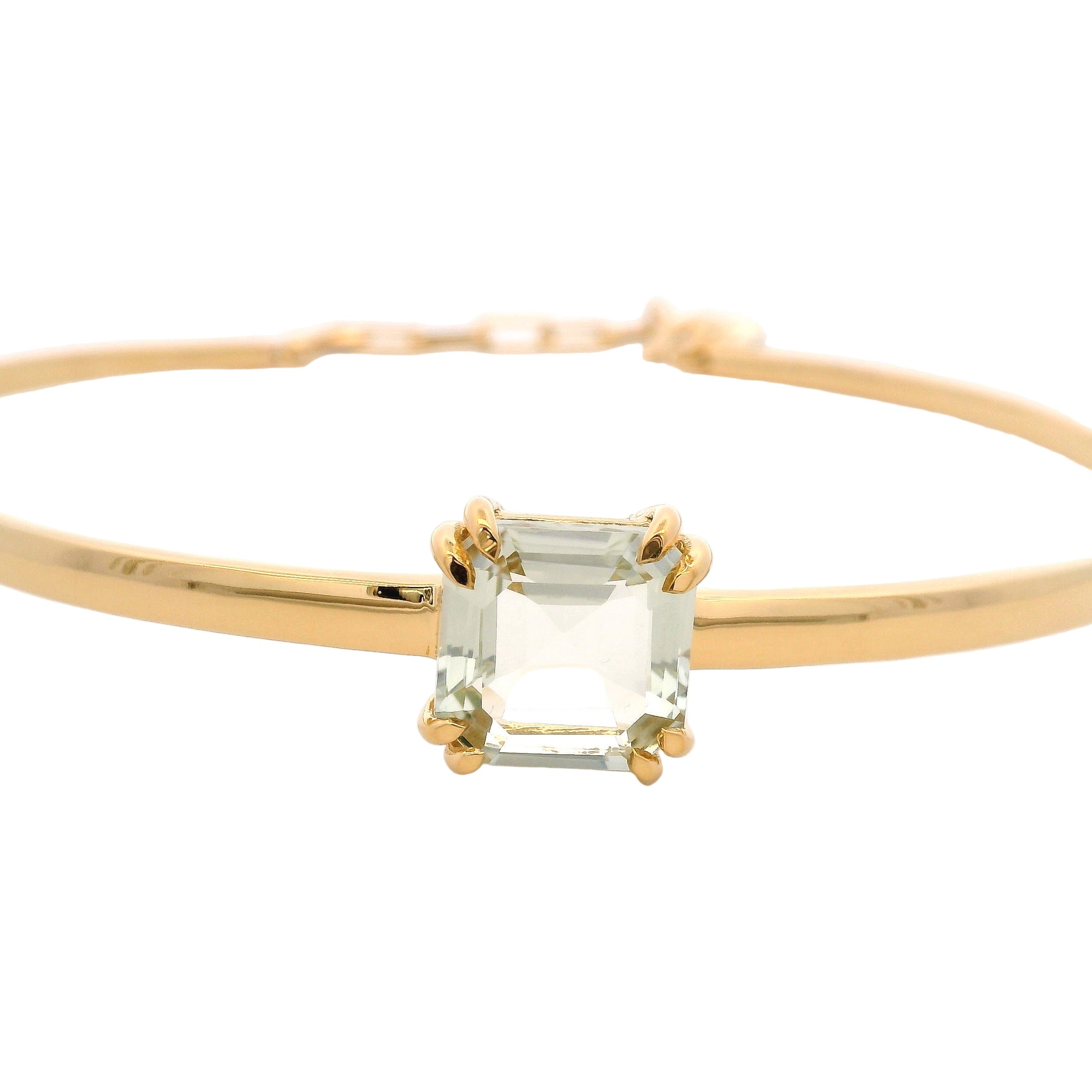 Gold bracelet with a clear gemstone on a white background