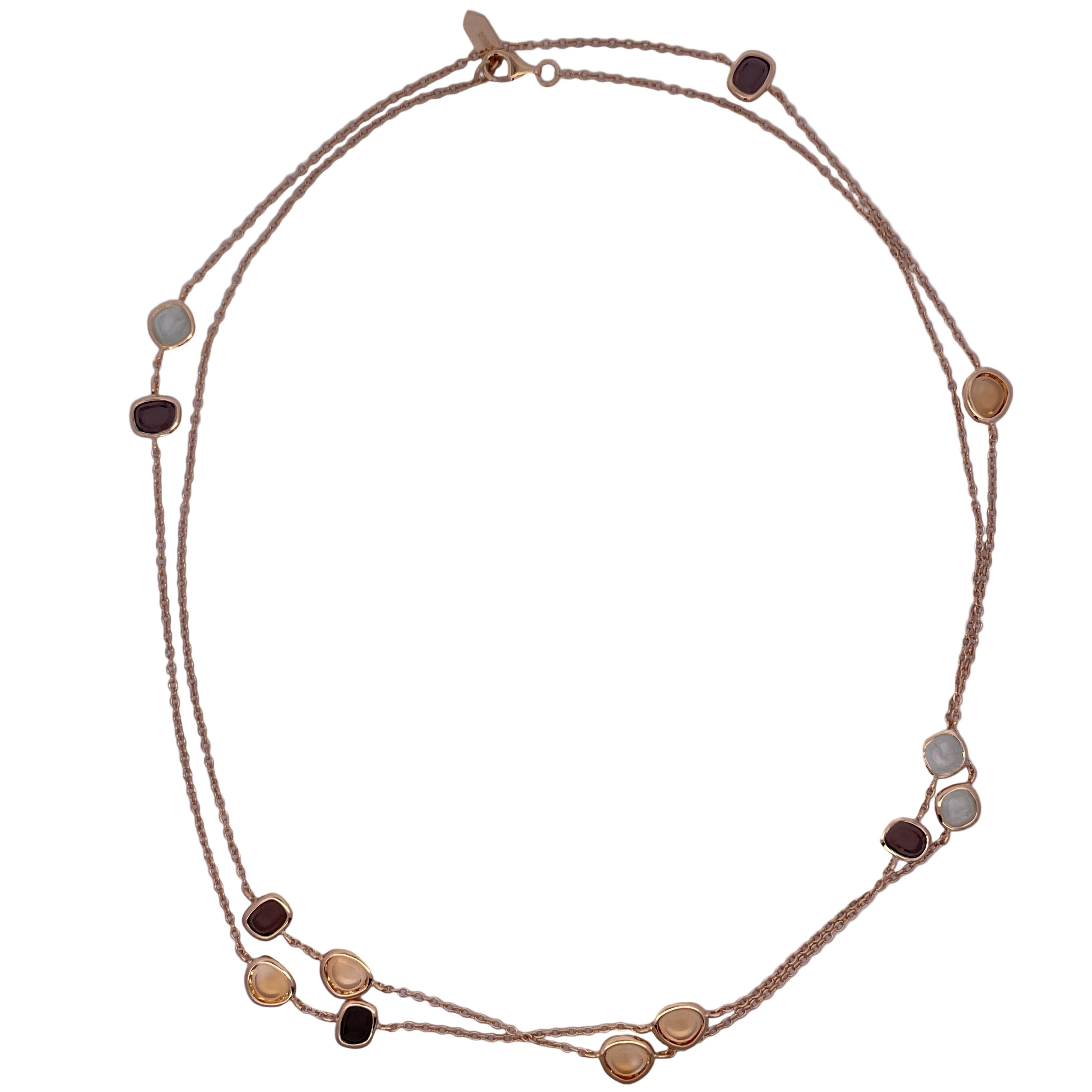 Gold necklace with gemstone accents on a white plate