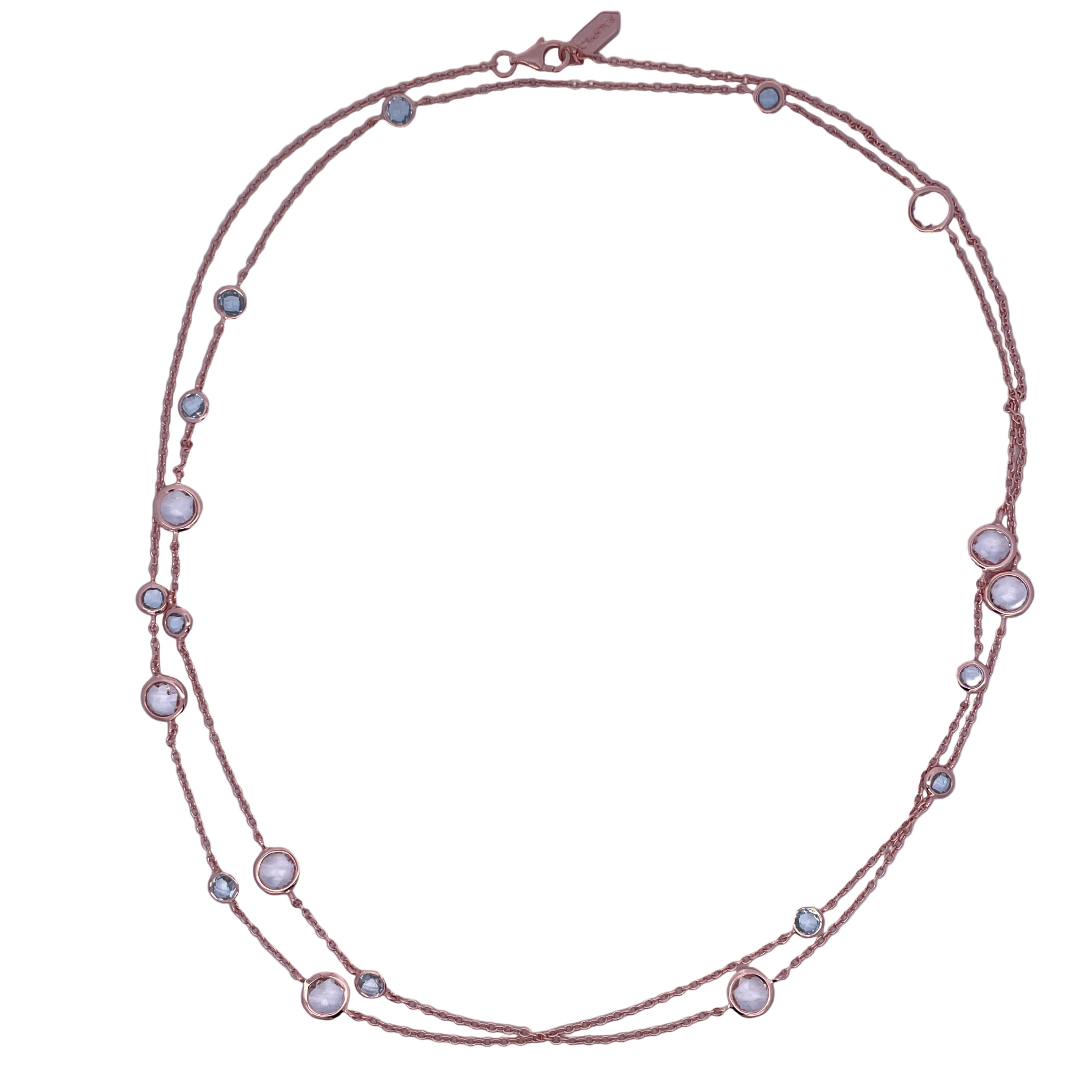 Rose gold necklace with small round stones on a light purple background
